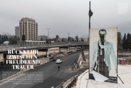 Doppelseite aus den „Fotos für die Pressefreiheit 2025“: Zerstörtes Straßenbild in Damaskus mit einem halb heruntergerissenen Propagandaposter von Baschar al-Assad. Im Hintergrund ein leerer Boulevard und ein massiver Verwaltungsbau, vorne links eine einzelne Person auf der Straße.